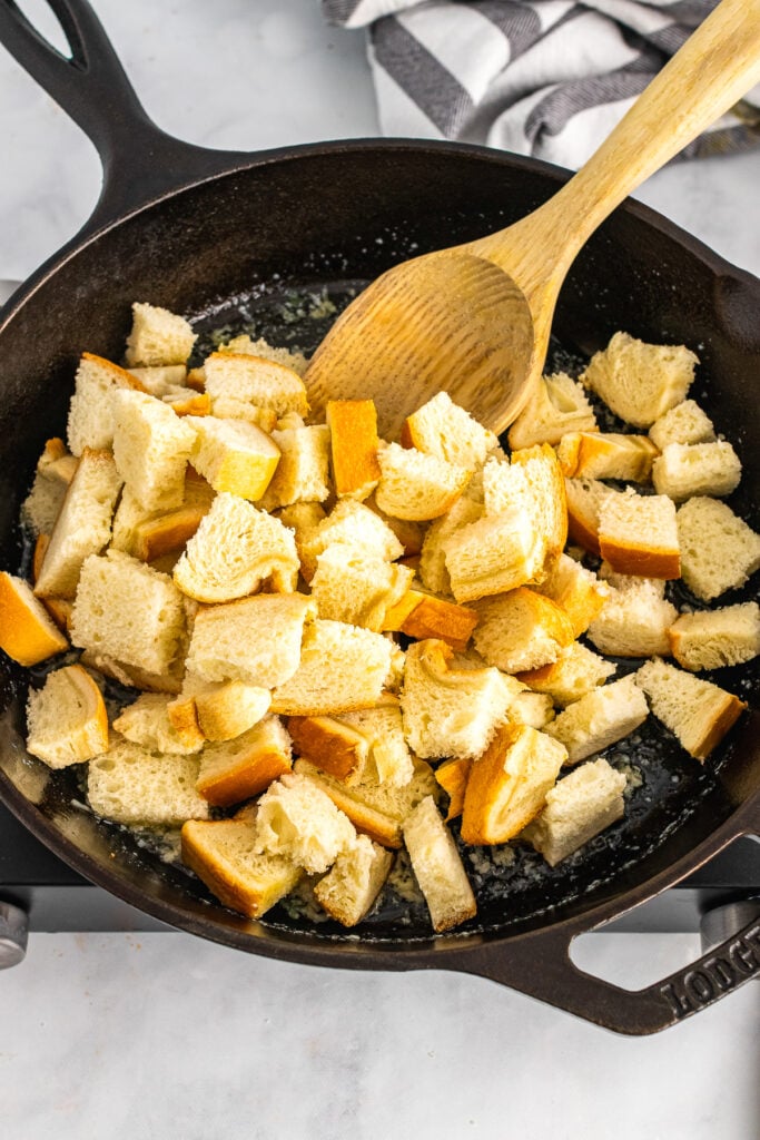 Bread cubes in butter sautéed in cast iron for croutons.