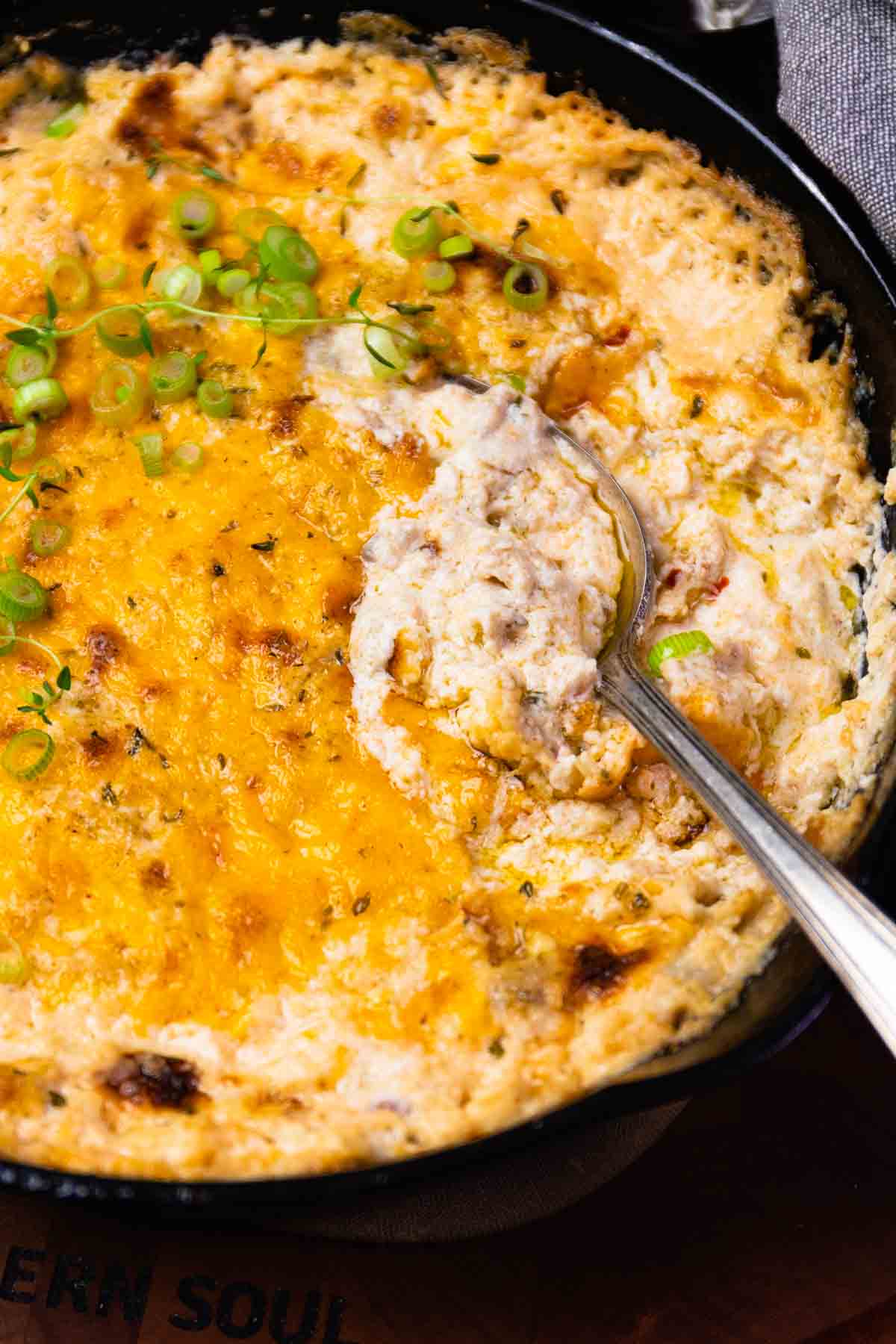 Baked ground beef casserole with melted cheddar cheese and green onions in black skillet, IMG 0638