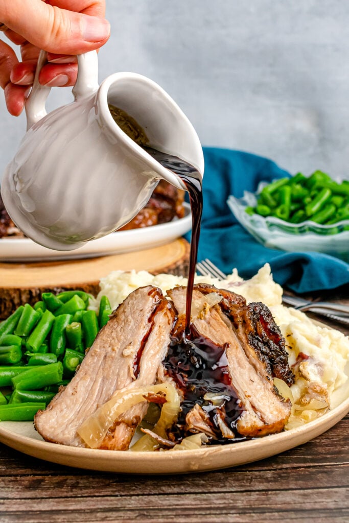 Balsamic drizzle poured over pork roast.