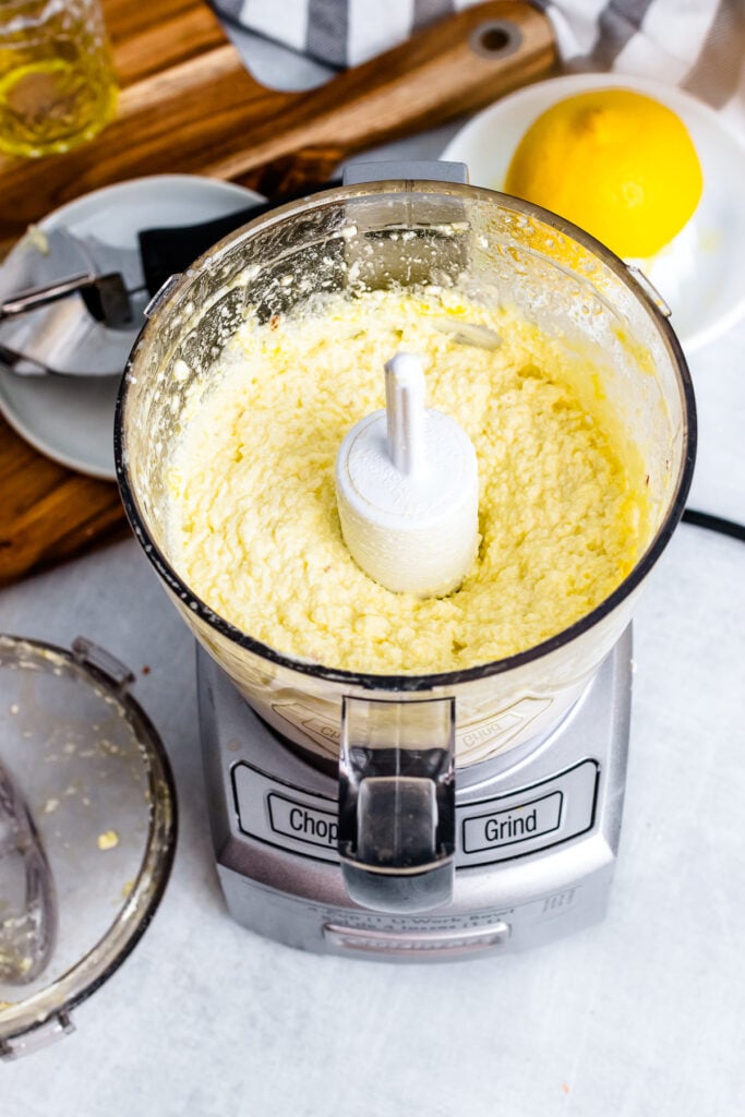 Whipped feta in the bowl of a food processor.
