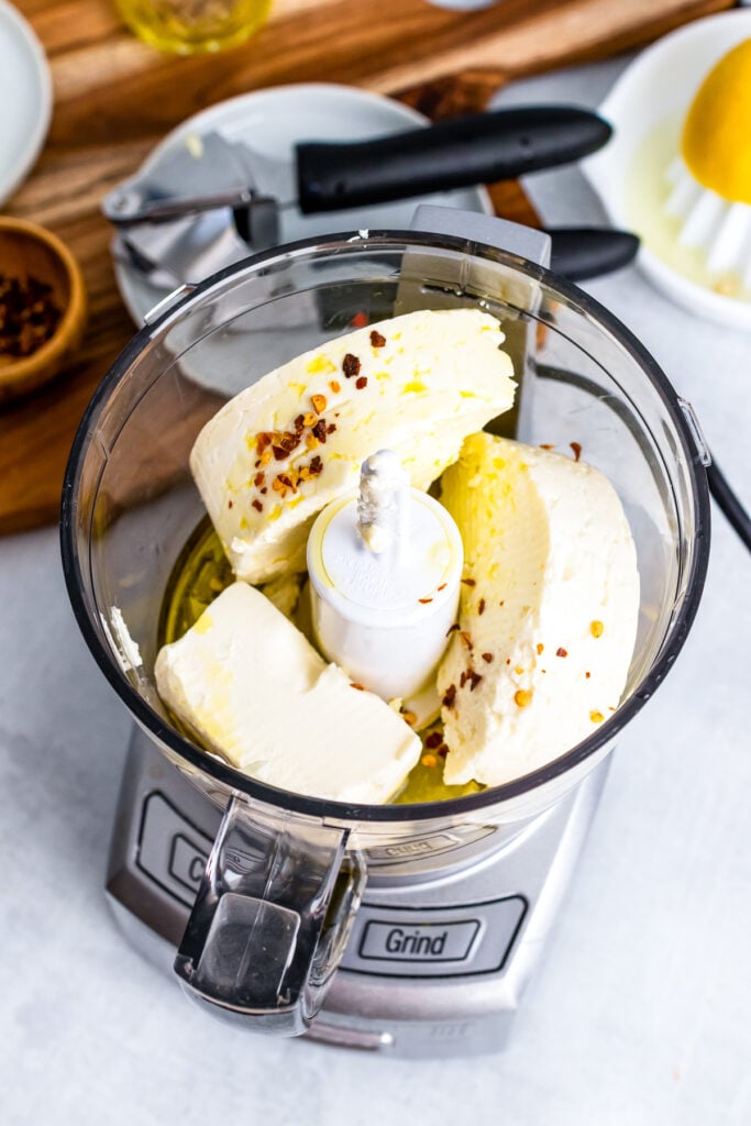 Food processor with whipped feta and red pepper flakes.