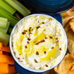 Blue bowl with Whipped Feta with olive oil and red pepper flakes.
