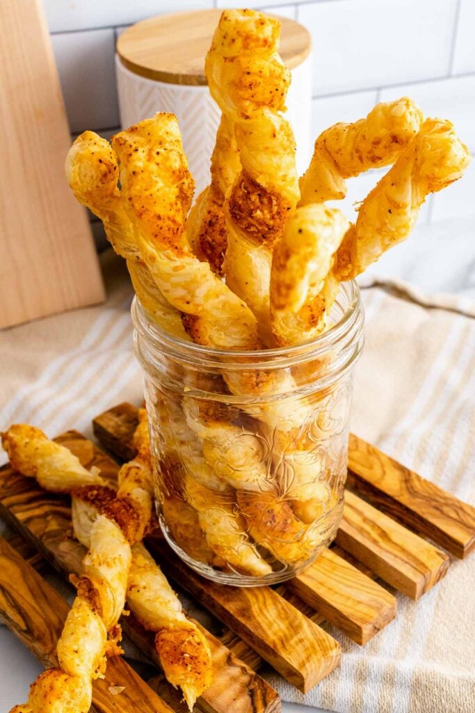 Baked Puffed Pastry Cheese Straws in a mason jar for serving.