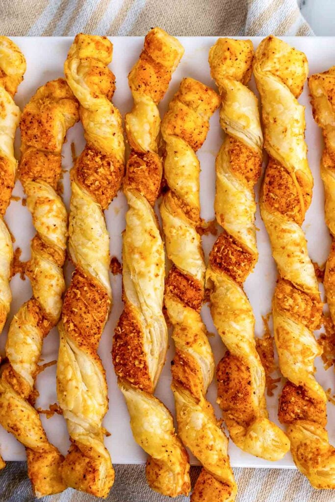 Puffed Pastry Cheese Straws baked to perfection on a serving tray.