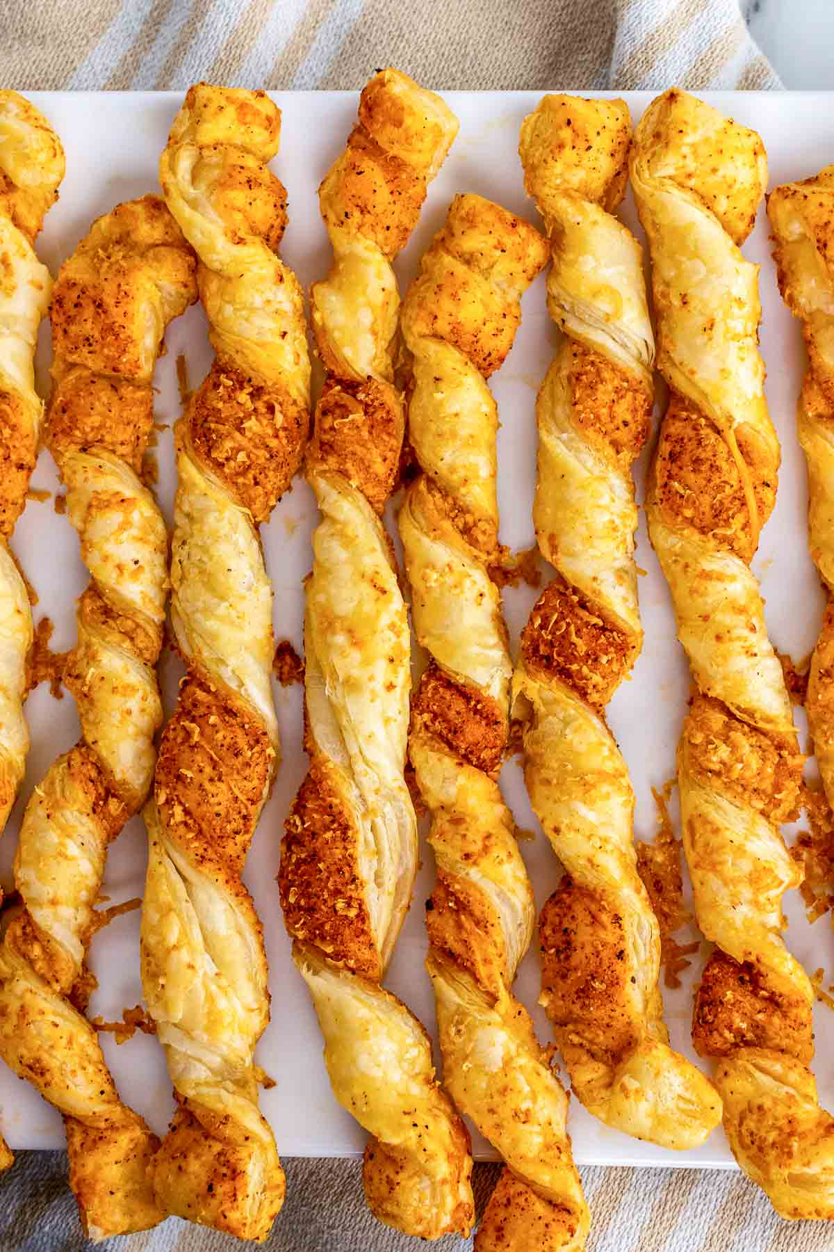 Puffed Pastry Cheese Straws baked to perfection on a serving tray.