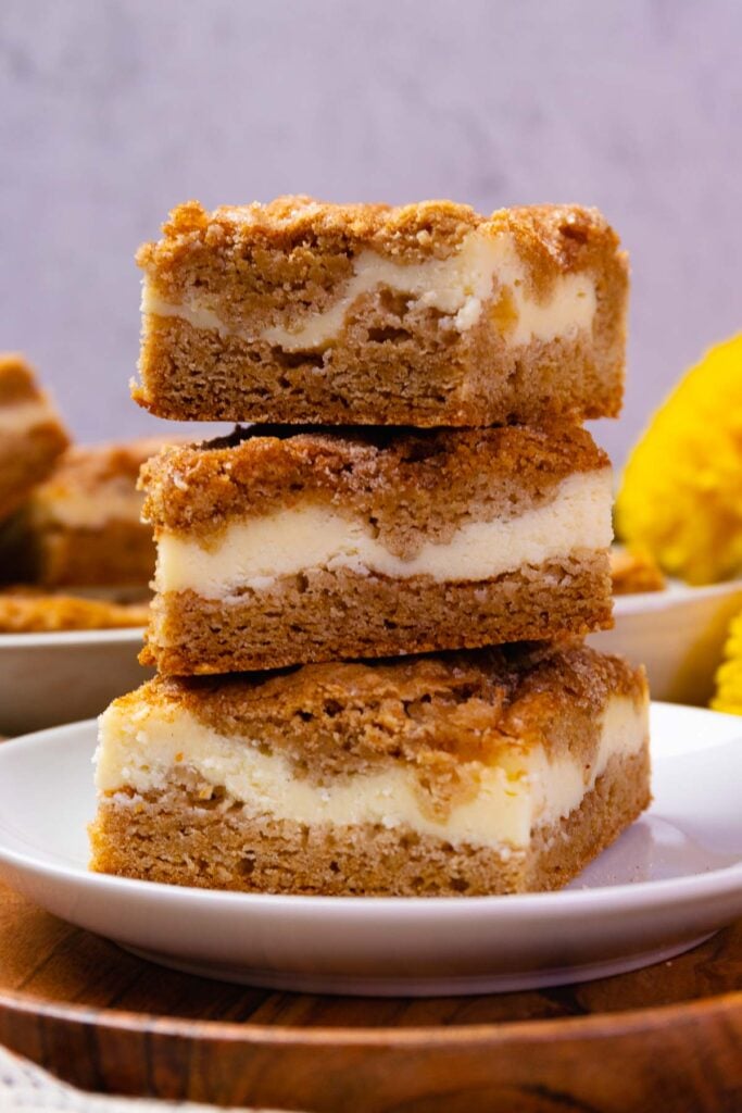 Snickerdoodle Cheesecake Bars stacked on a plate served for dessert.