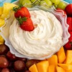 Strawberries in a bowl of 3-ingredient fruit dip surrounded with fresh fruit.