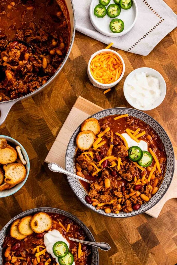 Two bowls of Bloody Mary Chili with toppings.