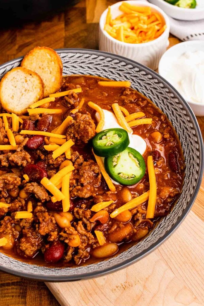 Bowl of Bloody Mary Chili with cheese, peppers and croutons.