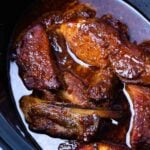 Pot of country style pork ribs cooked in a flavorful sauce in the crock pot.