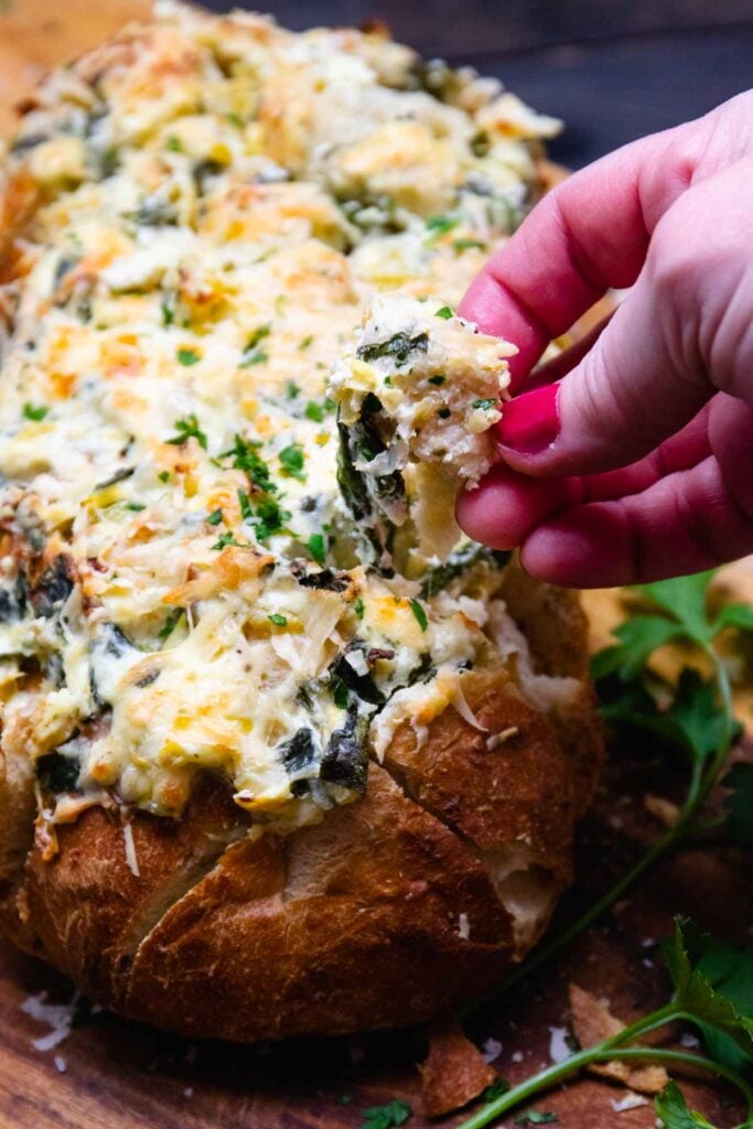 Spinach Artichoke bread with a chuck of bread pulled out.