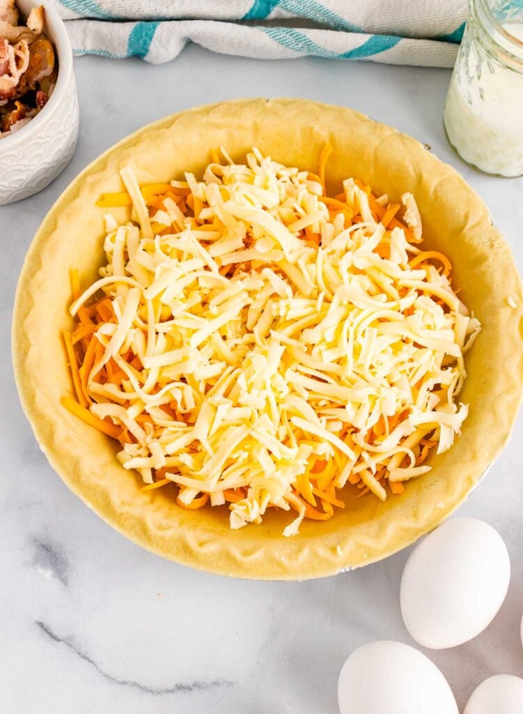 Unbaked bacon cheddar quiche in a prepared pie crust.