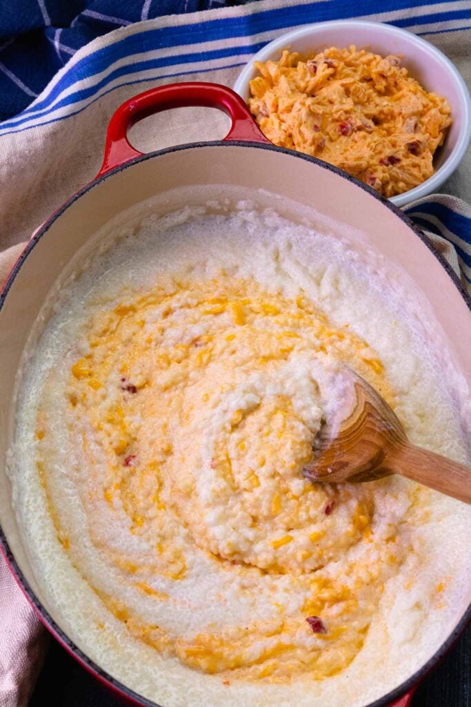 Pimento cheese being stirred into grits.