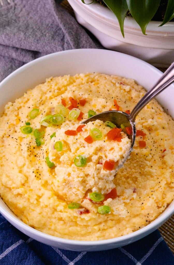 Spoonful of Pimento Cheese Grits in a white bowl served for brunch.