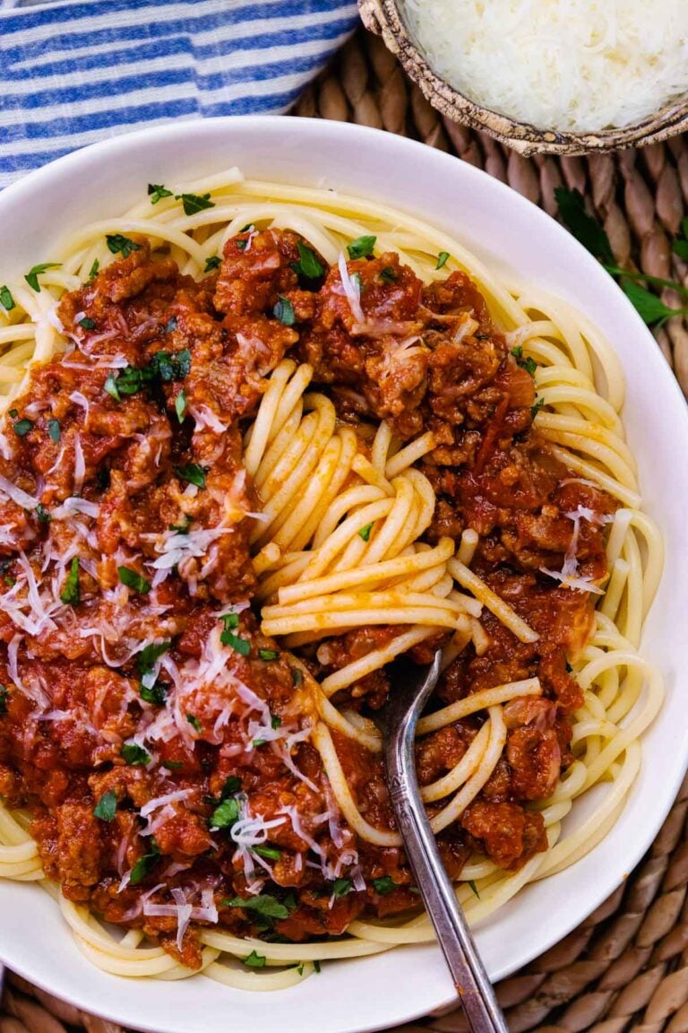 Bowl of spaghetti swirled on a fork with homemade meat sauce.