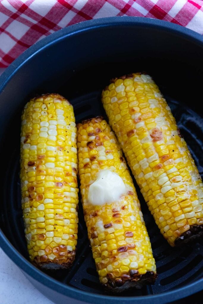 Air Fryer Corn On The Cob served with butter salt and pepper as a summer side dish.