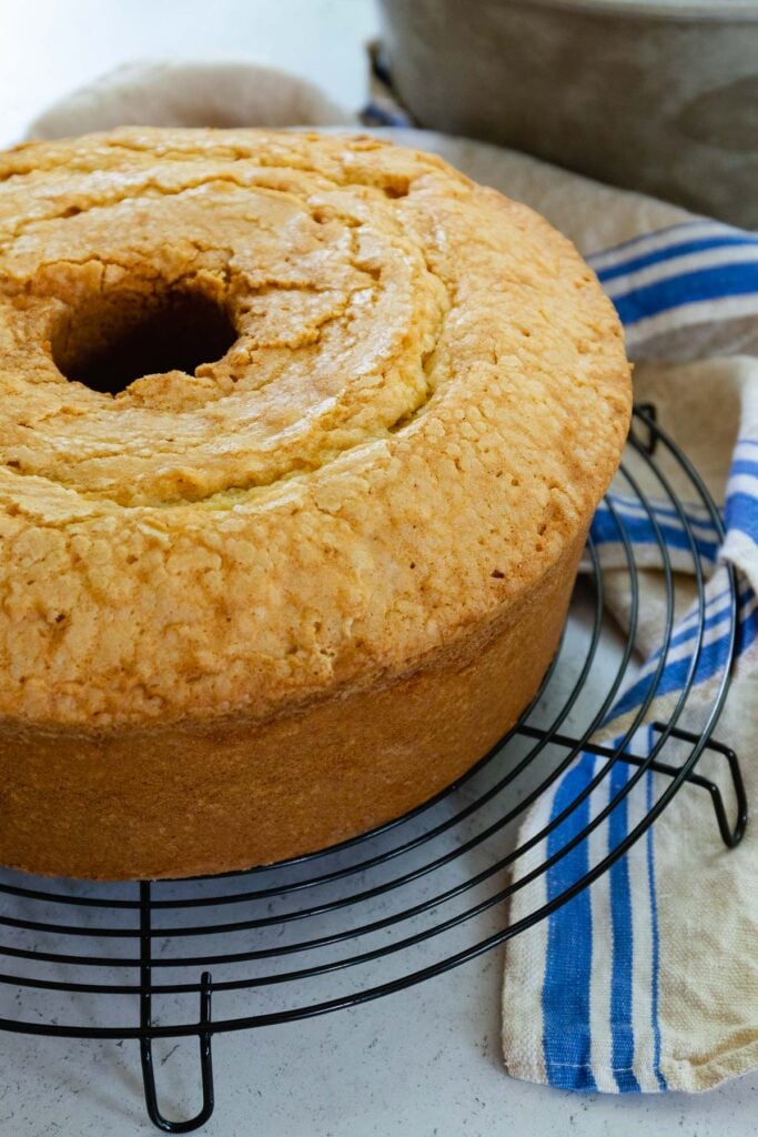 Million Dollar Pound Cake made with butter, sugar, flour, vanilla and almond extract cooking on a metal cake rack.