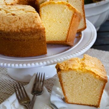 Slice of Million Dollar Pound Cake on a white plate along with sliced of cake served for dessert.