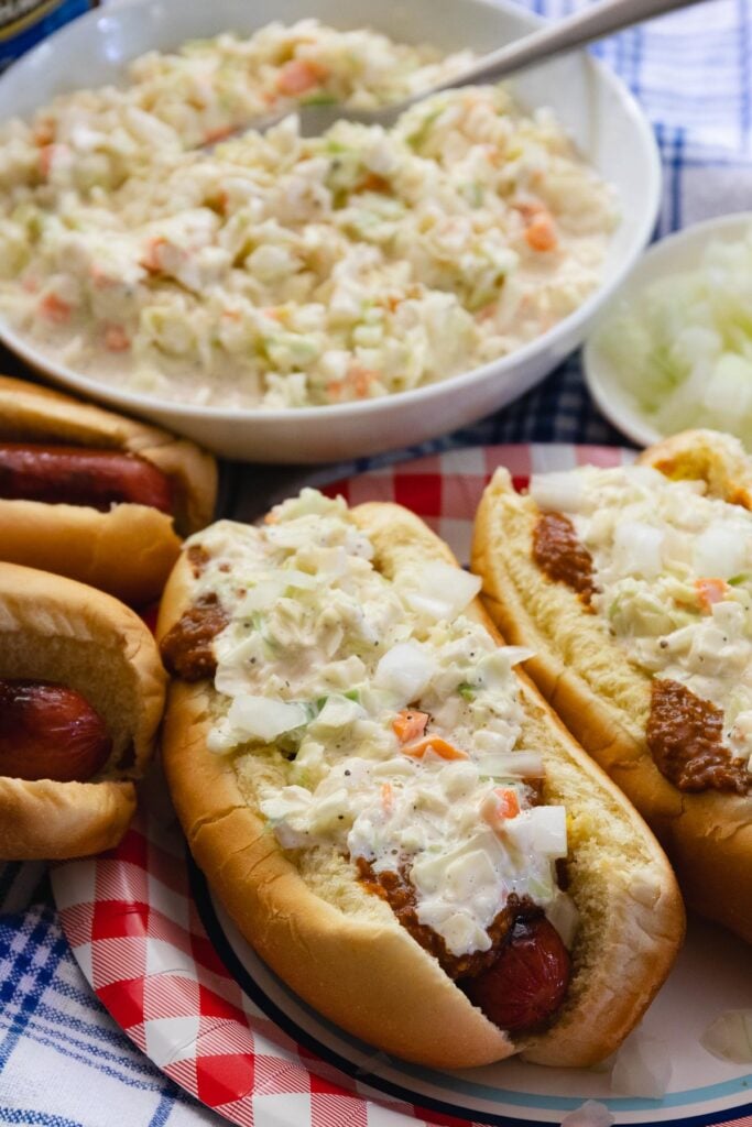 Carolina Slaw Dogs are loaded with flavor! Made with hot dogs in buns, mustard, chili, onions and creamy coleslaw.