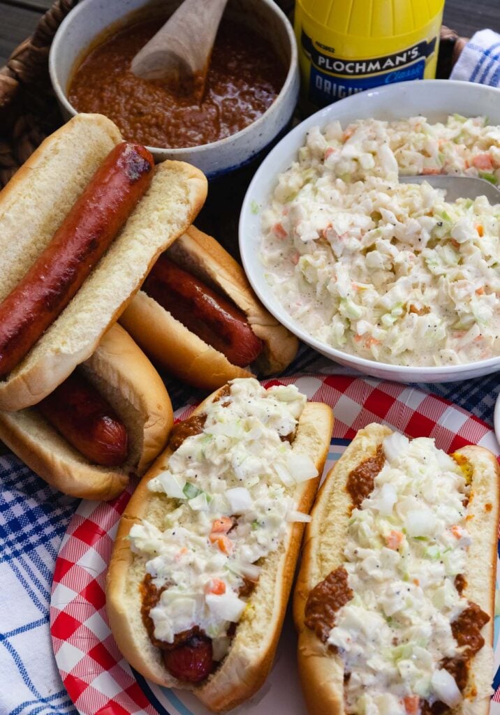 Carolina Slaw Dogs are loaded with flavor! Made with hot dogs in buns, mustard, chili, onions and creamy coleslaw.
