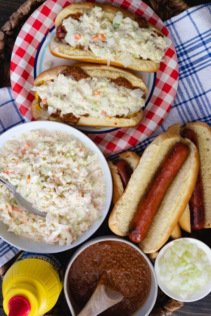 Carolina Slaw Dogs are loaded with flavor! Made with hot dogs in buns, mustard, chili, onions and creamy coleslaw.