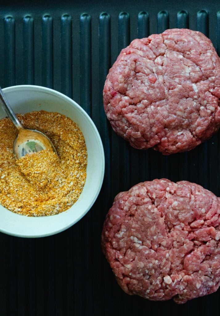 Hamburger patties on a grill with easy to make homemade seasoning.