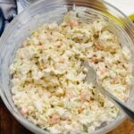 Creamy Southern coleslaw with shredded cabbage and carrots in a white bowl, a classic BBQ side dish.