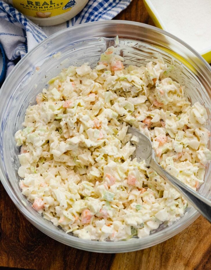 Creamy Southern coleslaw with shredded cabbage and carrots in a white bowl, a classic BBQ side dish.