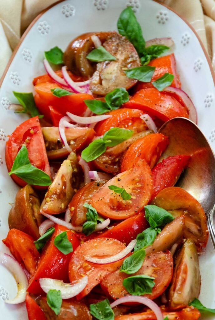 Fresh tomato Salad with basil and red onion is one of summers best side dished served with anything off the grill or just on it's own.