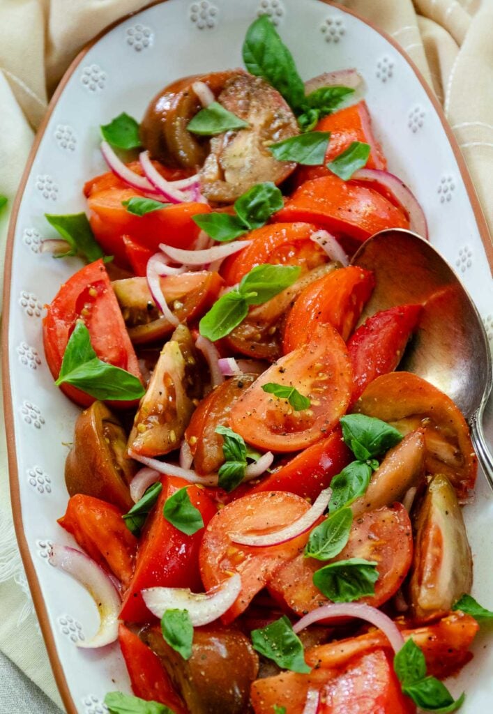 Fresh tomato Salad with basil and red onion is one of summers best side dished served with anything off the grill or just on it's own.
