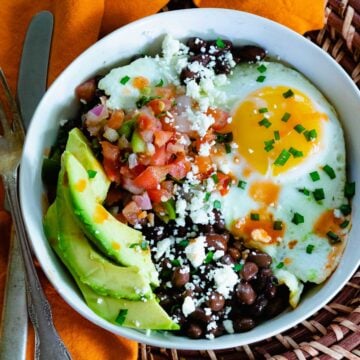 Healthy and delcious black bean breakfast burrito bowls with fried eggs, salsa and avocados.