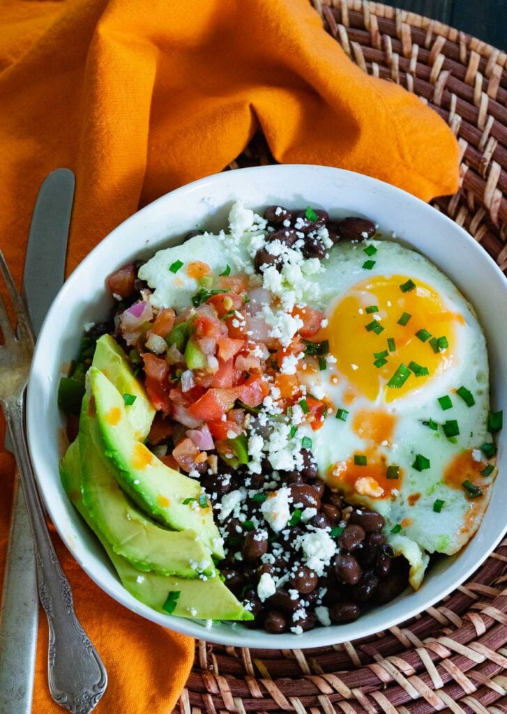 Healthy and delcious black bean breakfast burrito bowls with fried eggs, salsa and avocados.