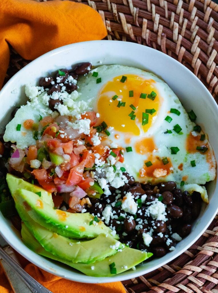 Avocado, black beans and salsa served for breakfast in a burrito bowl.