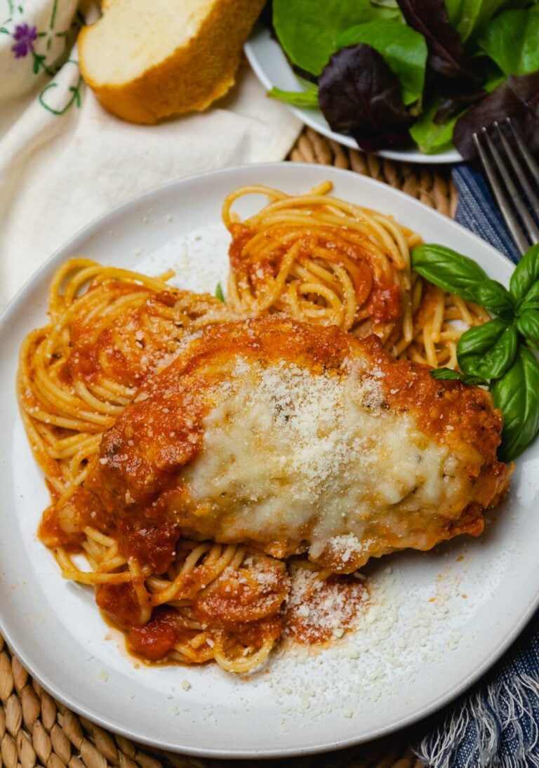 Crock Pot Chicken Parmesan served with cooked spaghetti, fresh bread and a green salad.
