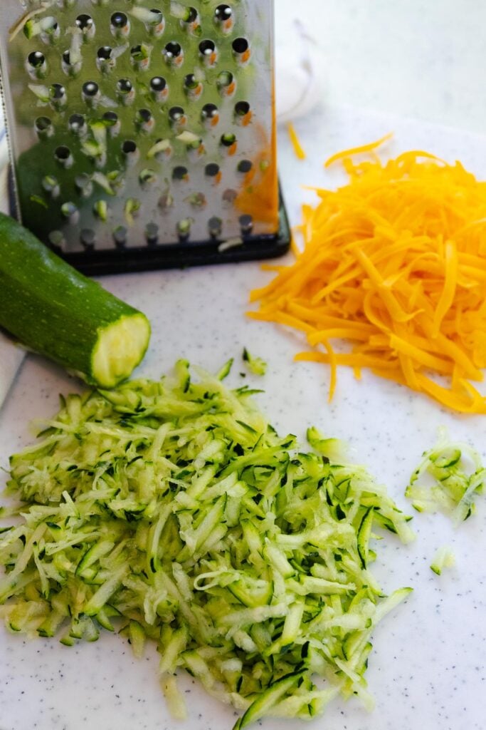 Grated zucchini and cheddar cheese for homemade baked zucchini cheese bread.