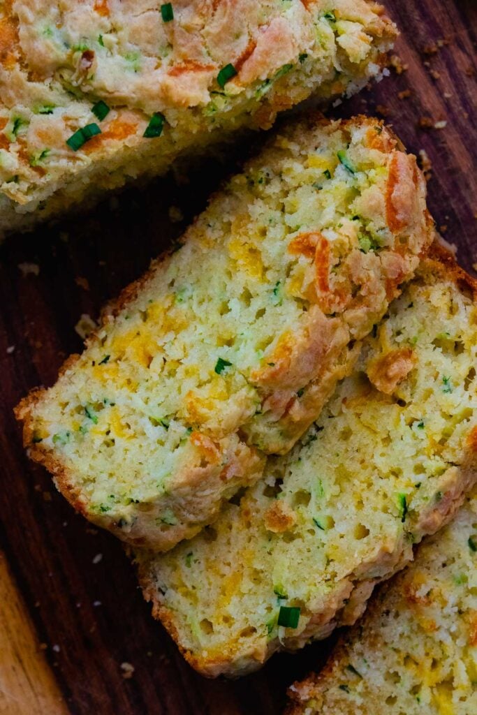 Sliced zucchini cheese bread served on a cutting board for an afternoon snack.