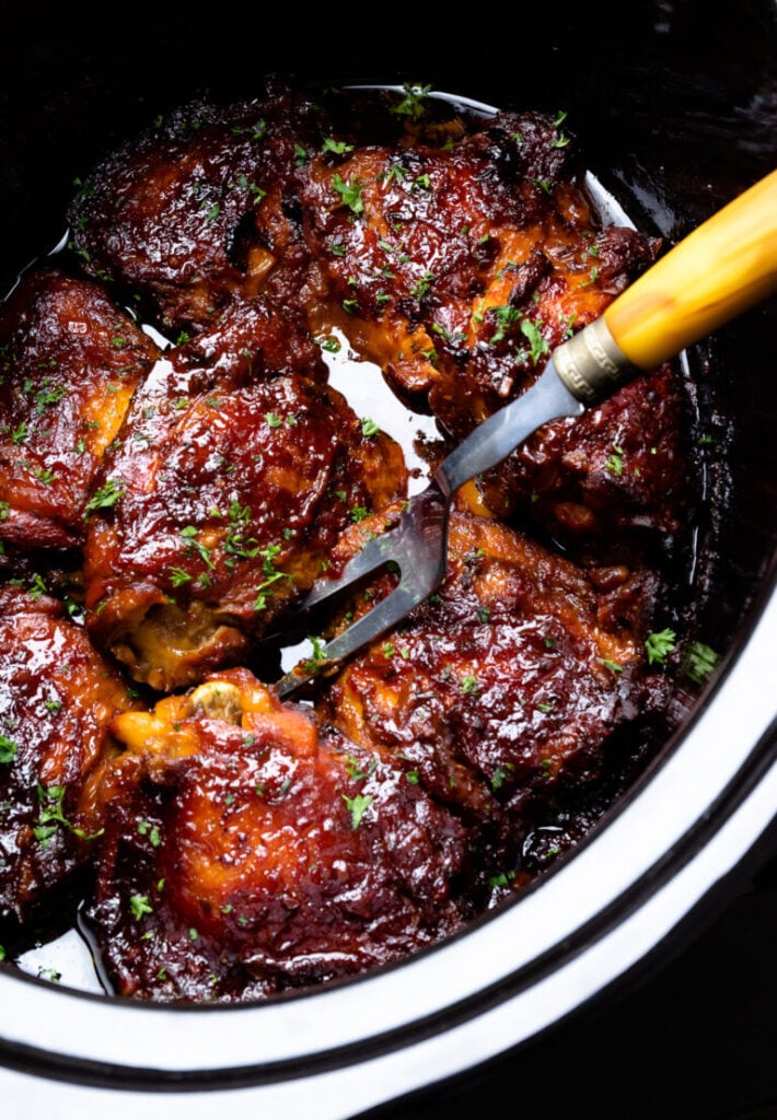 Glazed beef short ribs in slow cooker with fork, garnished with fresh parsley for Easy Slow Cooker Dinners for Busy Weeknights