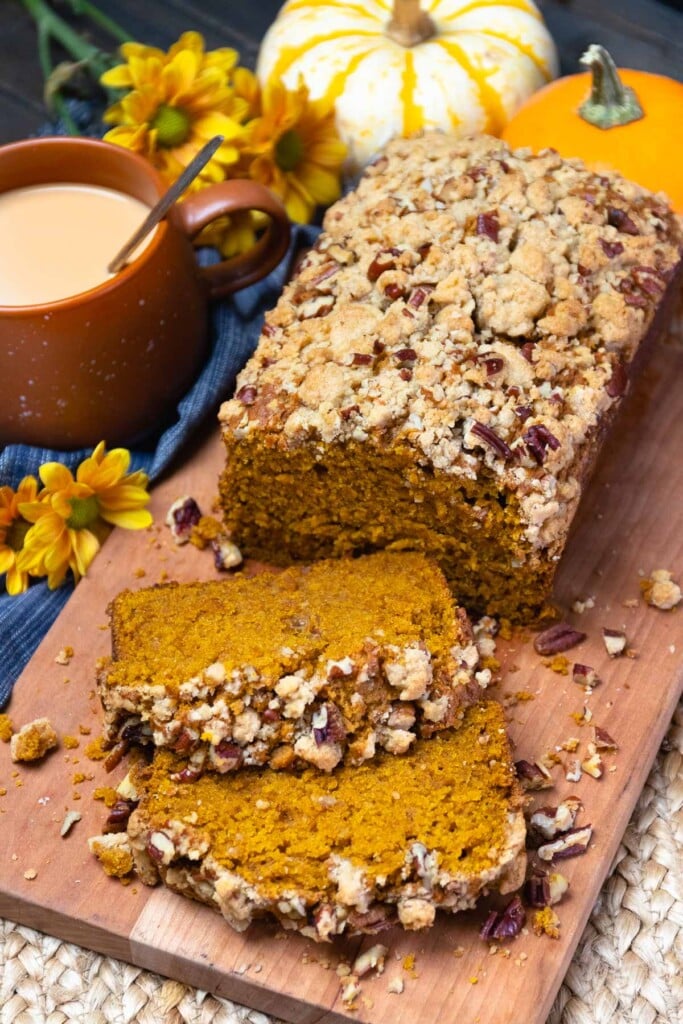 Pumpkin Bread topped with a pecan streusel sliced and served on a board is perfect for breakfast or a snack.