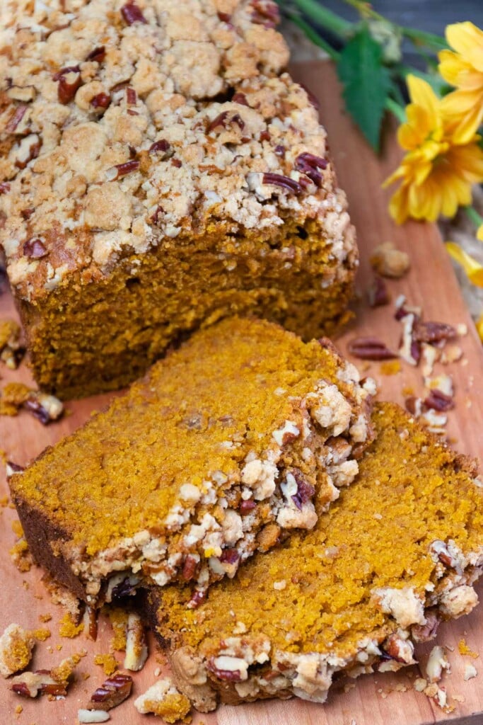 Pumpkin Bread topped with a pecan streusel sliced and served on a board is perfect for breakfast or a snack.