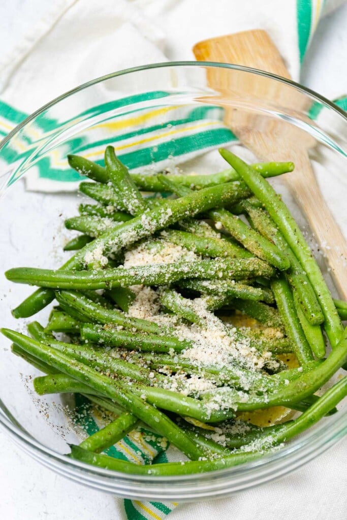 Green beans prepped with parmesan, garlic powder, salt and pepper to be cooked in the air fryere.