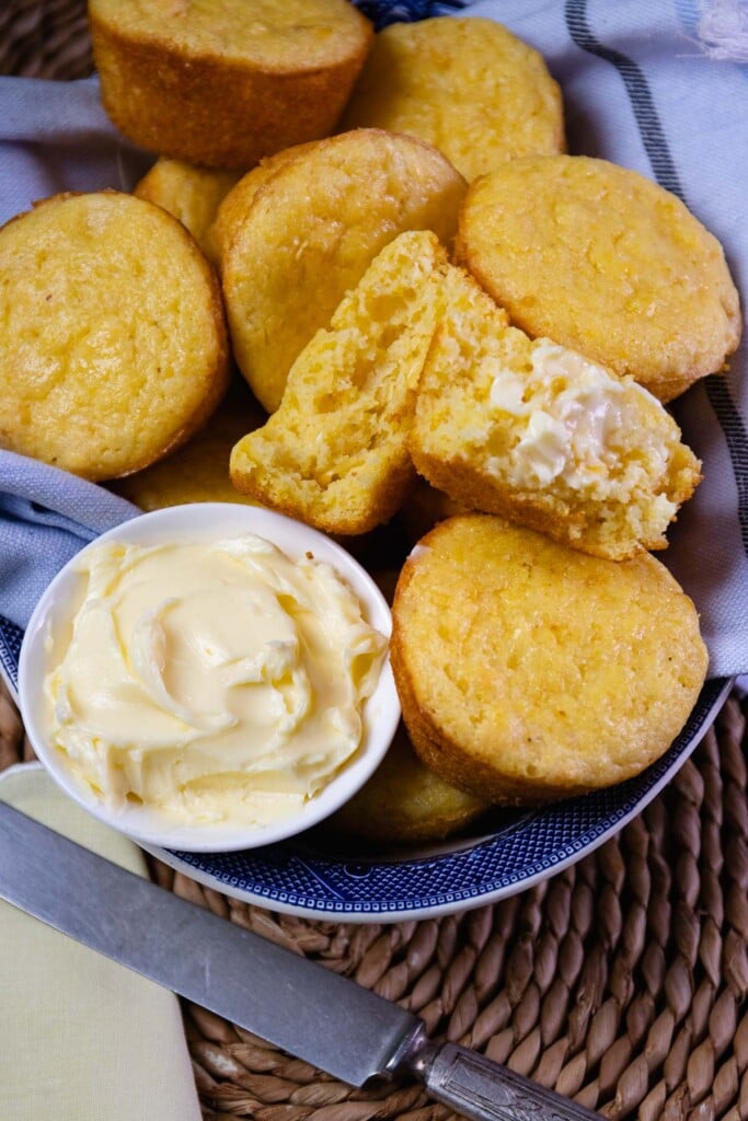 Corn Muffins served with butter, warm in a blue bowl for lunch or dinner.