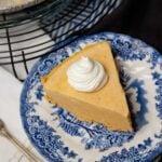 Slice of Creamy Pumpkin Icebox Pie with whipped cream served for dessert on a blue and white plate.
