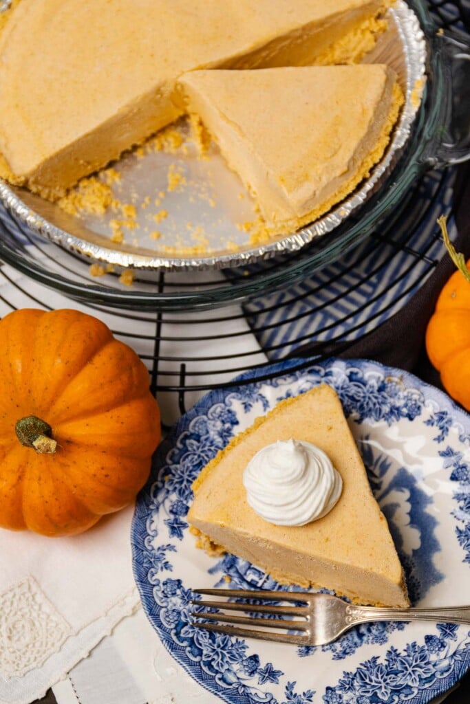 Slice of Pumpkin Icebox Pie served on a blue plate with whipped cream.