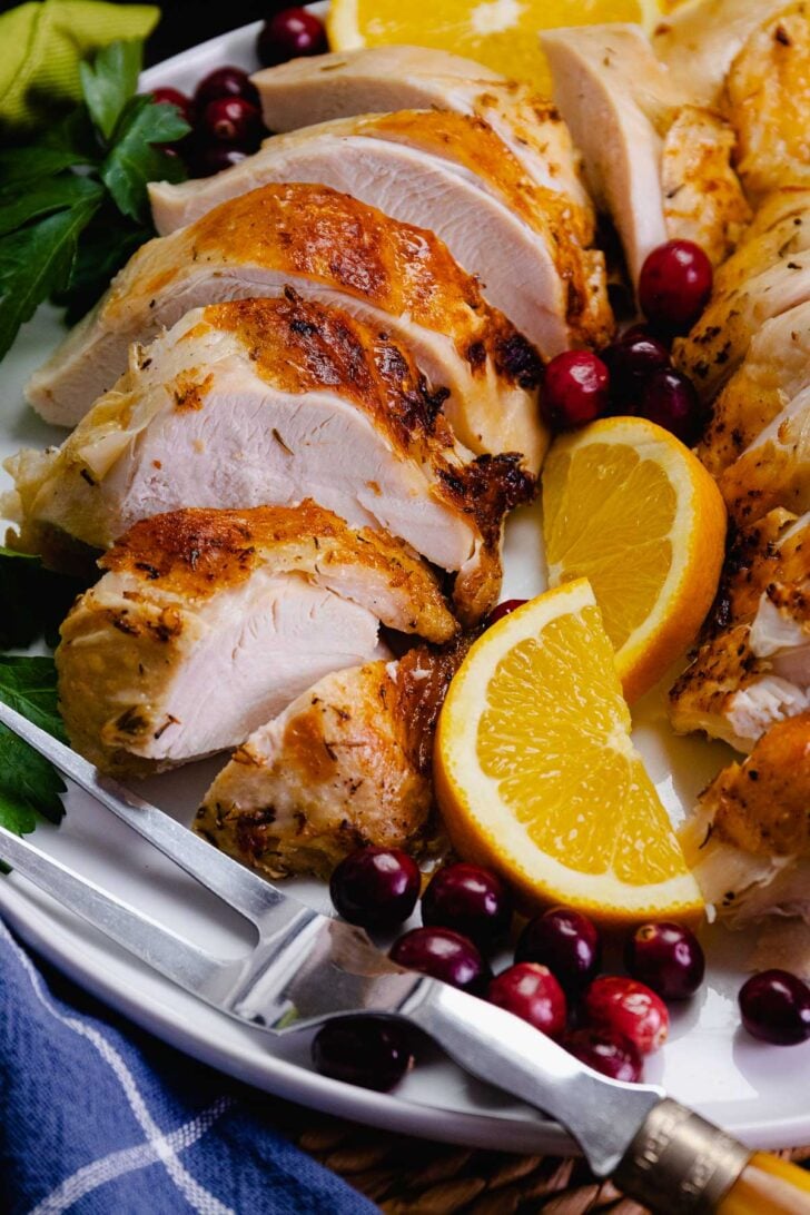 Perfectly cooked tender turkey breast made in the crock pot is sliced and ready to serve for the holidays.