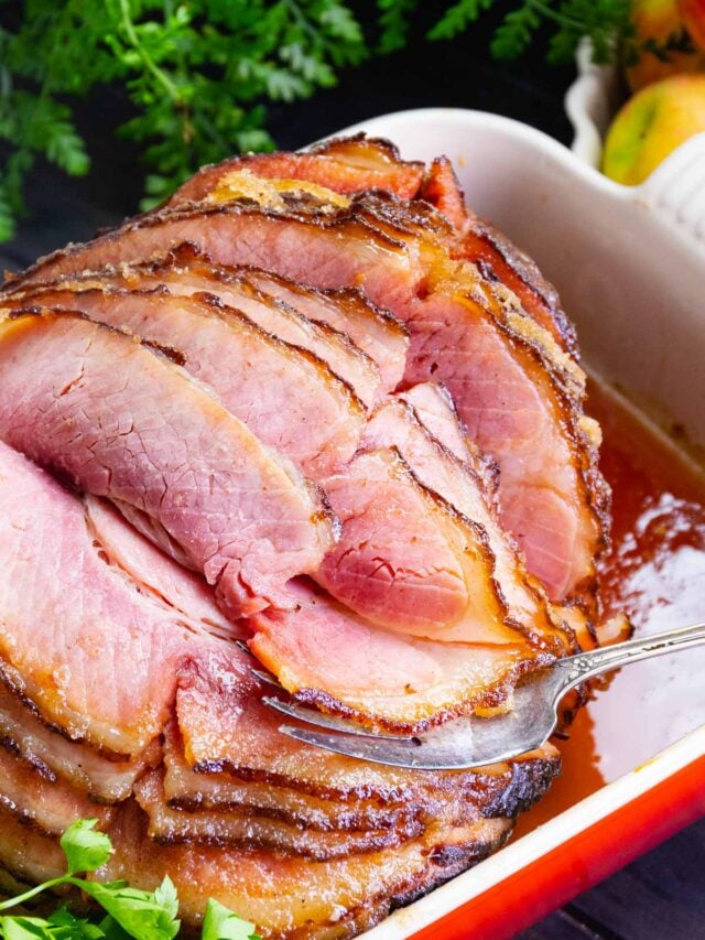 Honey Baked Ham cooked in a sweet glaze is a copycat recipe that's easy to make and over the top delicious.
