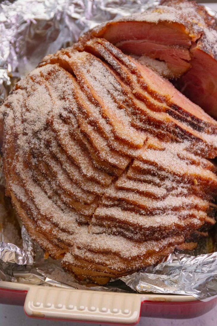 Sugar and warm spices are sprinkle over a spiral sliced bone-in ham to make Copycat Honey Baked Ham at home that cheaper than ordering on line.