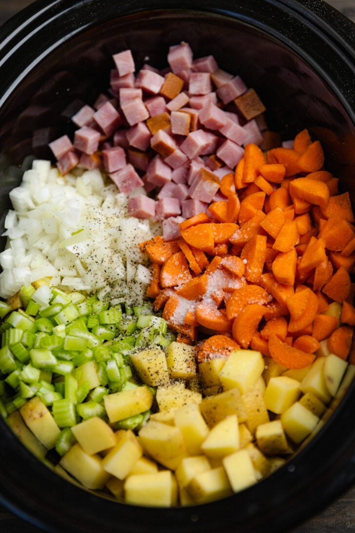Ham, carrots, potatoes, celery and onion in a crock pot are the ingredients to make Ha and Potato Soup.