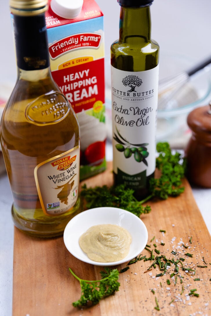 Olive oil, vinegar, heavy cream, dijon, salt pepper and chives are the simple ingredients used to make creamy vinaigrette.