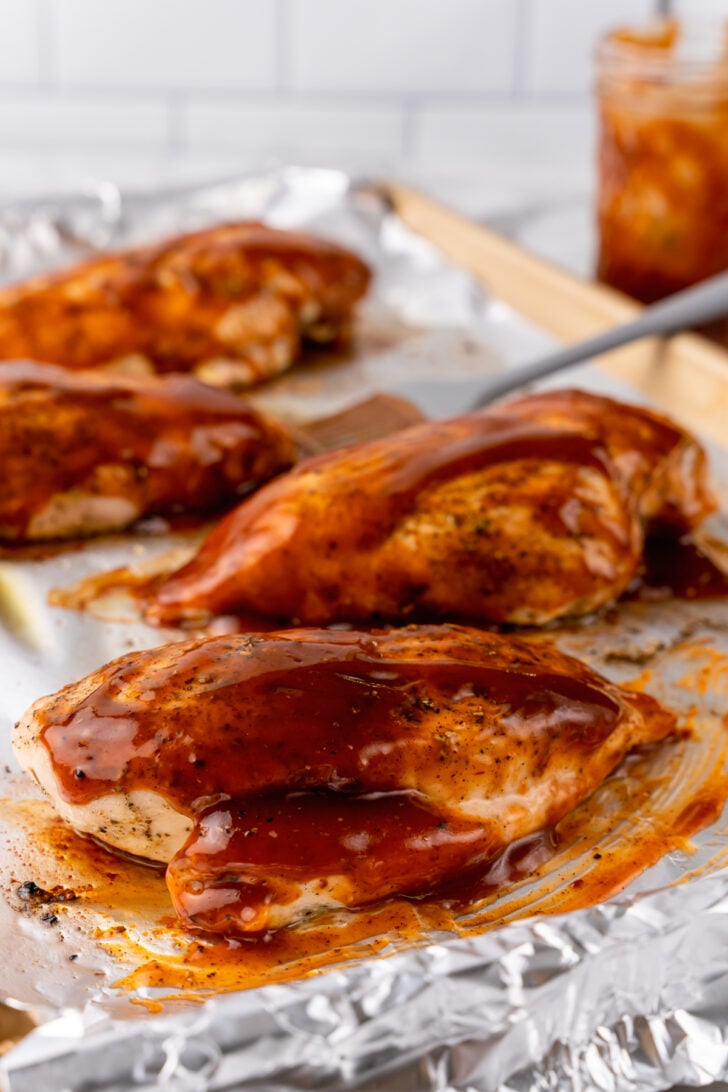 Tender, and juicy oven baked chicken with a rich BBQ sauce with all the flavors you love from summer grilling is easy to make and the perfect weeknight meal.