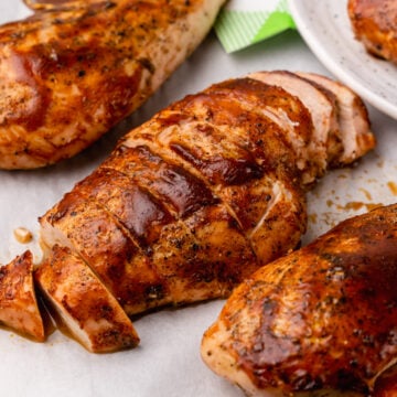 Tender, and juicy oven baked chicken with a rich BBQ sauce with all the flavors you love from summer grilling is easy to make and the perfect weeknight meal.